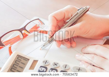 Businesswoman Working With Calculator And Pen