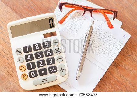 Top View Of Calculator, Pen, Eyeglasses And Bank Account Passbook