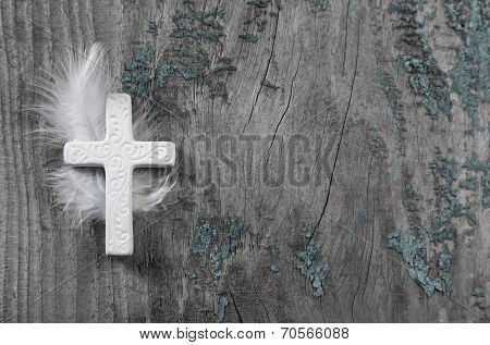 White Cross With Feather On An Old Rustic Background.