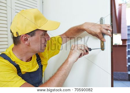 Male handyman carpenter worker at interior wood door lock installation or repairing