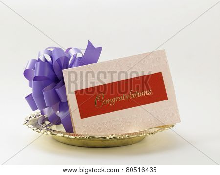 purple ribbon bow and a congraturation card
