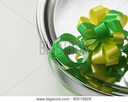 green yellow ribbon bows on the silver plate