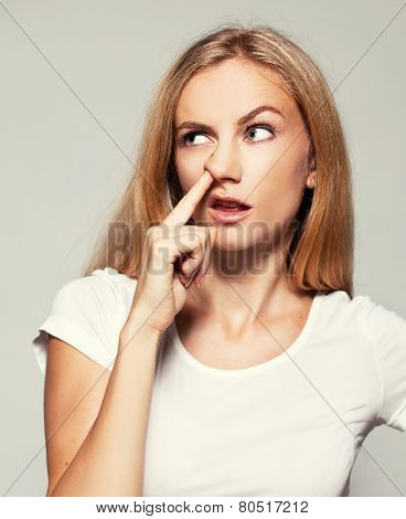 Woman picks his nose finger. Female climbs a finger in nose. Embarrassment