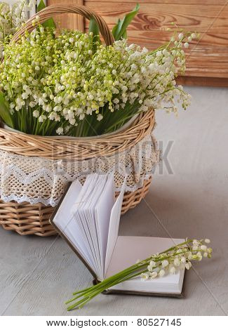 Basket With Lilies Of The Valley (convallaria Majalis) And Notebook With Blank Pages