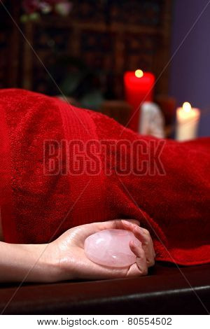 Closeup on young woman receiving hot stone massage