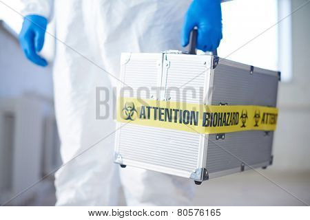 Medical case with biohazard held by gloved scientist