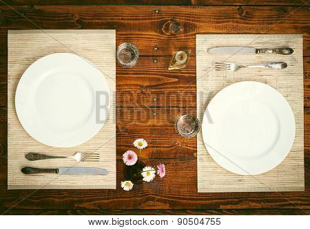 Table setting for two with empty plates - rustic wooden table