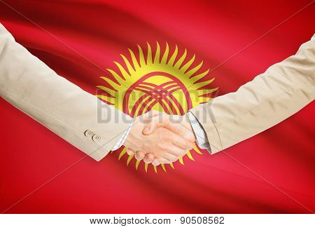 Businessmen Handshake With Flag On Background - Kyrgyzstan