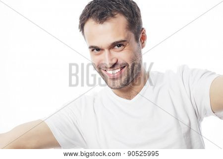 Tehnology and people concept: Happy selfie. Handsome young man holding camera and making selfie and smiling.
