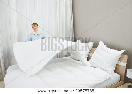 Female Housekeeping Worker Making Bed