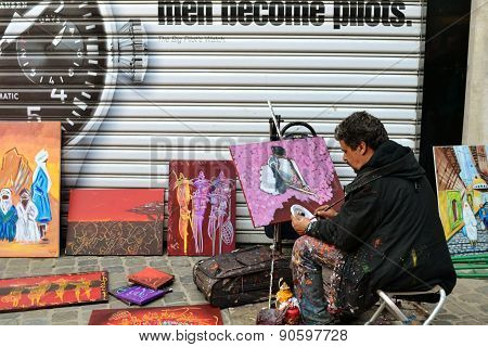 Street artist draws and sells paintings in Belgium