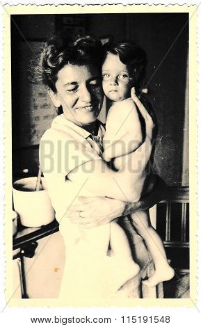 Vintage photo of mother and baby. Photo with dark tint circa 1941.