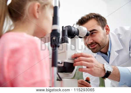 optician with tonometer and patient at eye clinic