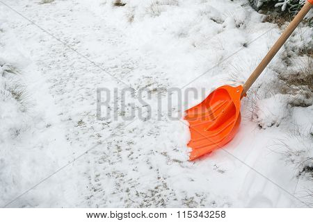 Snow removal. Orange Shovel in snow