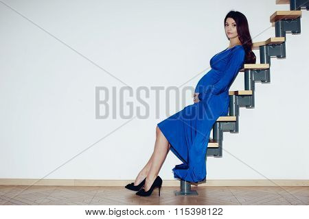 Pregnant girl sitting on a ladder