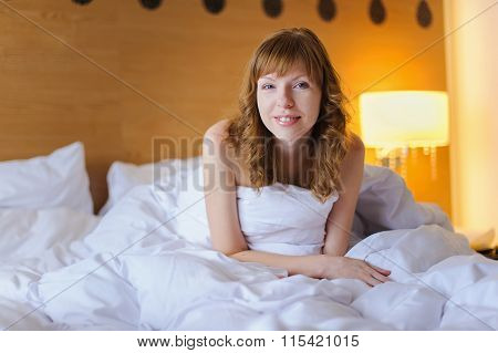 Girl smiling while sitting in bed