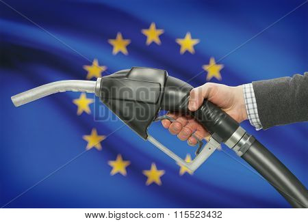 Fuel Pump Nozzle In Hand With National Flag On Background - European Union - Eu