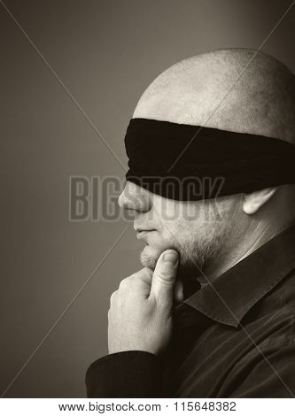 Portrait of a man with band on eyes. 
Black and white photos
