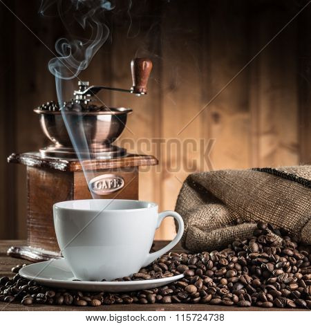 still life with coffee beans and old coffee mill on the wooden background 