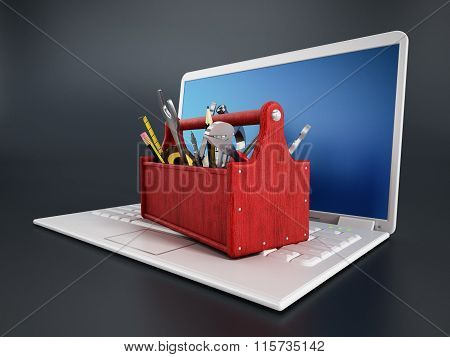 Red toolbox standing on laptop computer isolated on black background