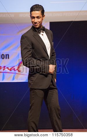 Male Physique Model Shows His Best In Suit On Stage