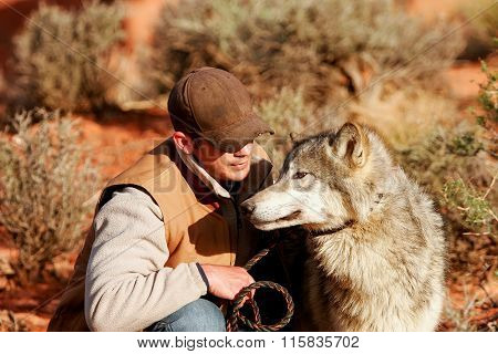 ARIZONA, USA - APRIL 16: Unidentified man - animal trainer sits with gray wolf on April 16, 2007 in Arizona, USA. The gray wolf is one of the world's best known and well researched animals