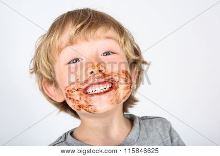 Young messy boy with chocolate on his face