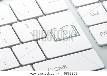 Learning concept: Book on computer keyboard background