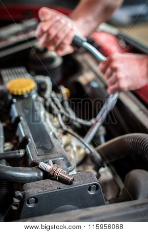 Starting ignition plug Car mechanic in auto repair service