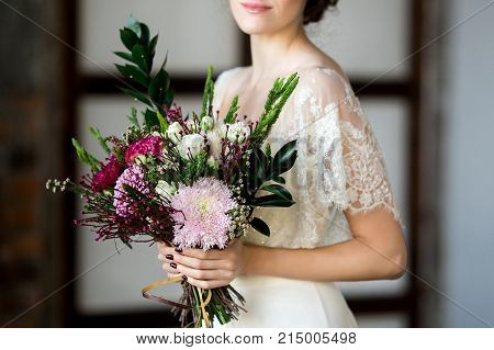 Beautiful Bride holding big wedding bouquet on wedding ceremony