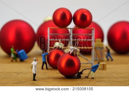 Miniature people worker figures at warehouse christmas balls