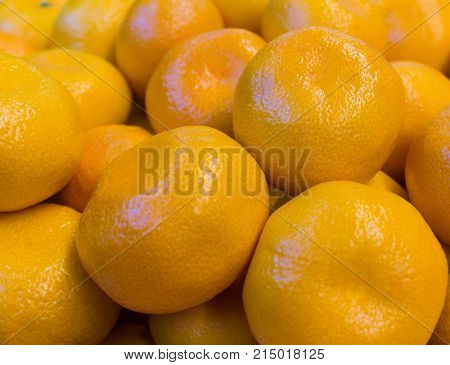 Fresh orange and yellow tangerines closeup close