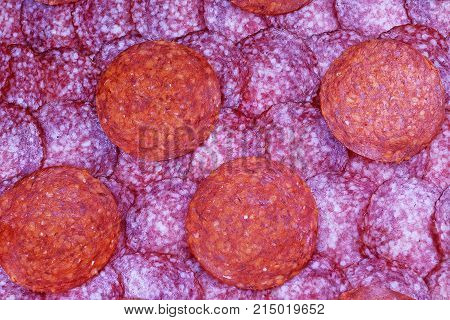 Texture with cut salami design. Sliced salami sausage pattern. Snags red meat pattern texture background. Pink red pork sausages.