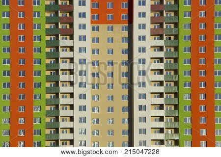 The facade of a typical block multi-storey residential building. Front view close up.