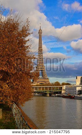 Color fall image of the Eiffel tower in Paris, France, Europe, on a sunny autumn day with blue sky and colorful leaves .