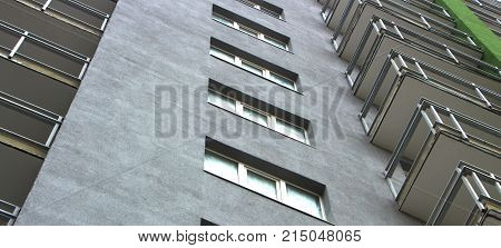 The facade of a typical block multi-storey residential building. Front view close up.