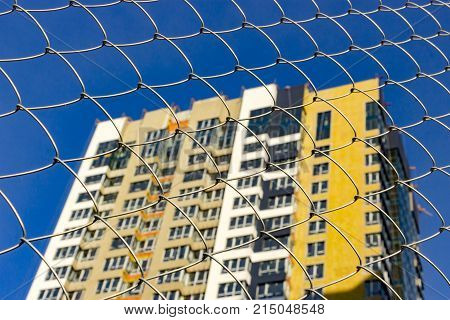 The facade of a typical block multi-storey residential building. Front view close up.