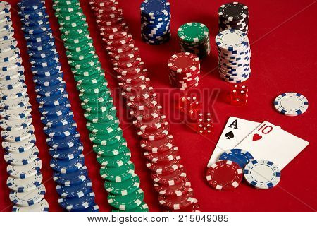 Two cards and chips on a red background. Big bet of game money. Cards - Ace and Ten. Your distribution at the table. Casino background. Copy space. Still life.