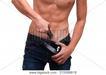 A guy with a naked, inflated torso shaves his hair with a trimmer underneath his belly on a white isolated background