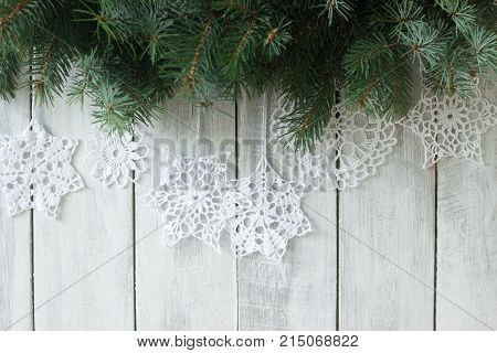 Christmas Or New Year Background With Fir Branches And Knitted White Snowflakes On A White Backgroun