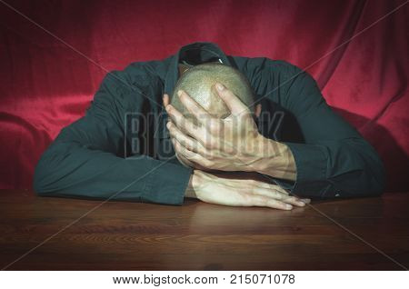 Depression. Young depressed and miserable man in black shirt sitting alone and feeling emotional pressure depression and anxiety selective focus