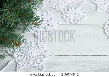 Christmas Or New Year Background With Fir Branches And Knitted White Snowflakes On A White Backgroun