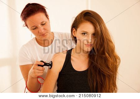 Physiotherapist doing Tecar therapy alterantive treatment on a woman patient