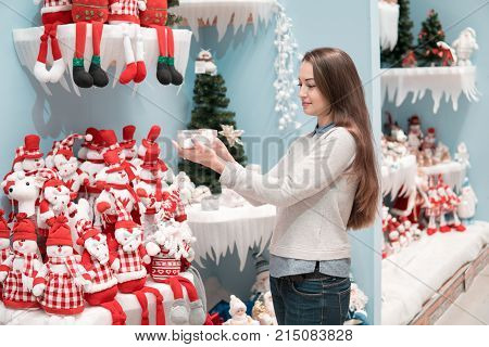 Cheerful happy customer girl choosing gifts for Christmas and New Year