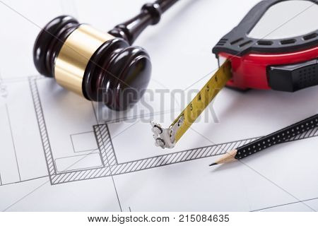 Close-up Of Gavel Measuring Instrument And Pencil On Blueprint