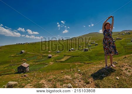 Young happy woman against mountain landscapes near Khulo village of Georgian Adjara region