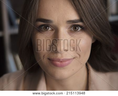 Moments of life. Closeup of portrait of cute smiling woman face with beautiful brown eyes in cozy studio