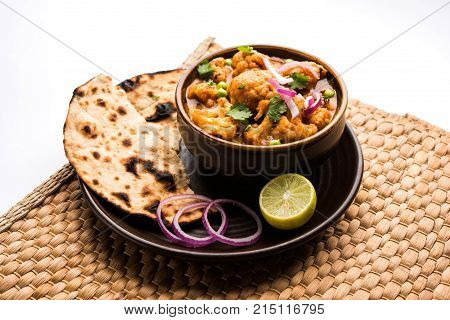 Aloo Gobi matar is a famous Indian curry dish with potatoes and cauliflower and green peas, selective focus