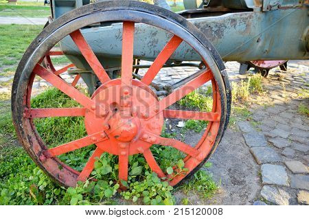 old red iron wheel fused into the ground