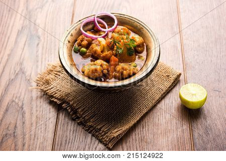 Aloo Gobi matar is a famous Indian curry dish with potatoes and cauliflower and green peas, selective focus